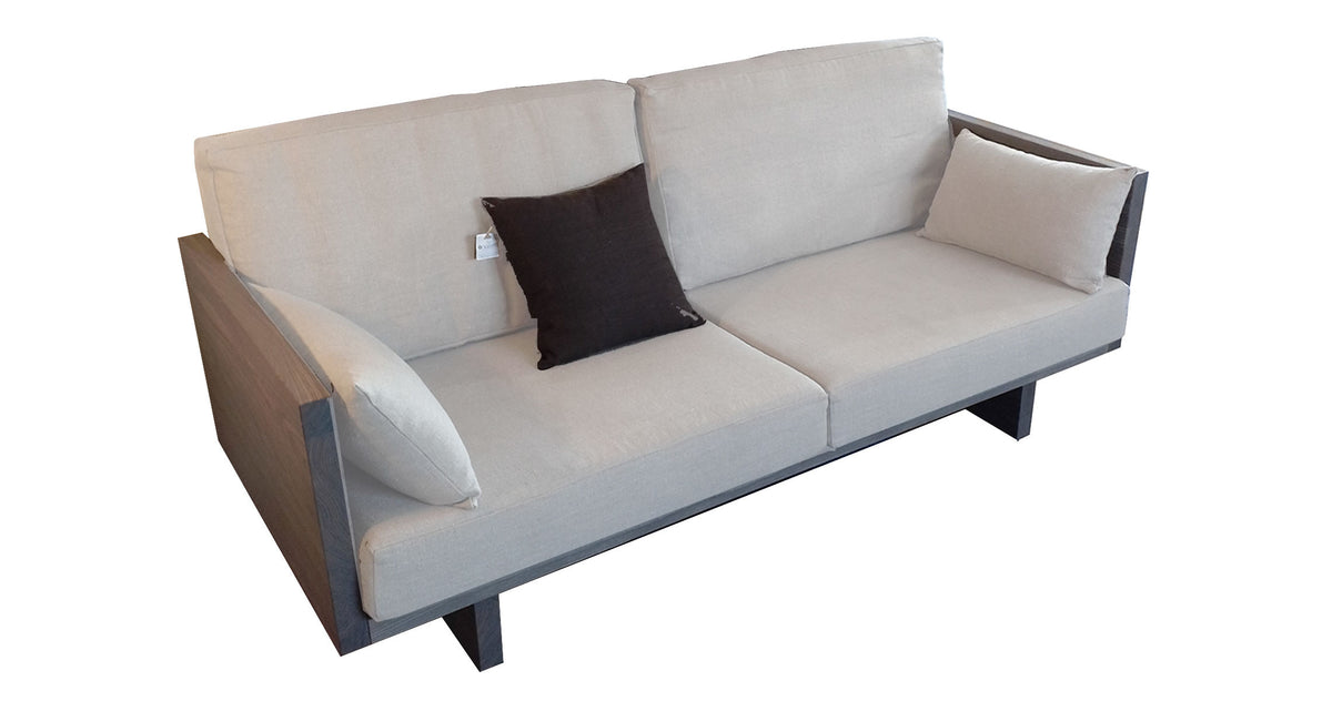 Canapé moderne en bois gris avec coussins beige, accoudoirs en bois et dossier rembourré, siège profond.