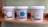 Trois pots de peinture naturelle Anachromie sur une étagère: blanc, bleu vif et vert pâle. Fabrication Rhône Alpes