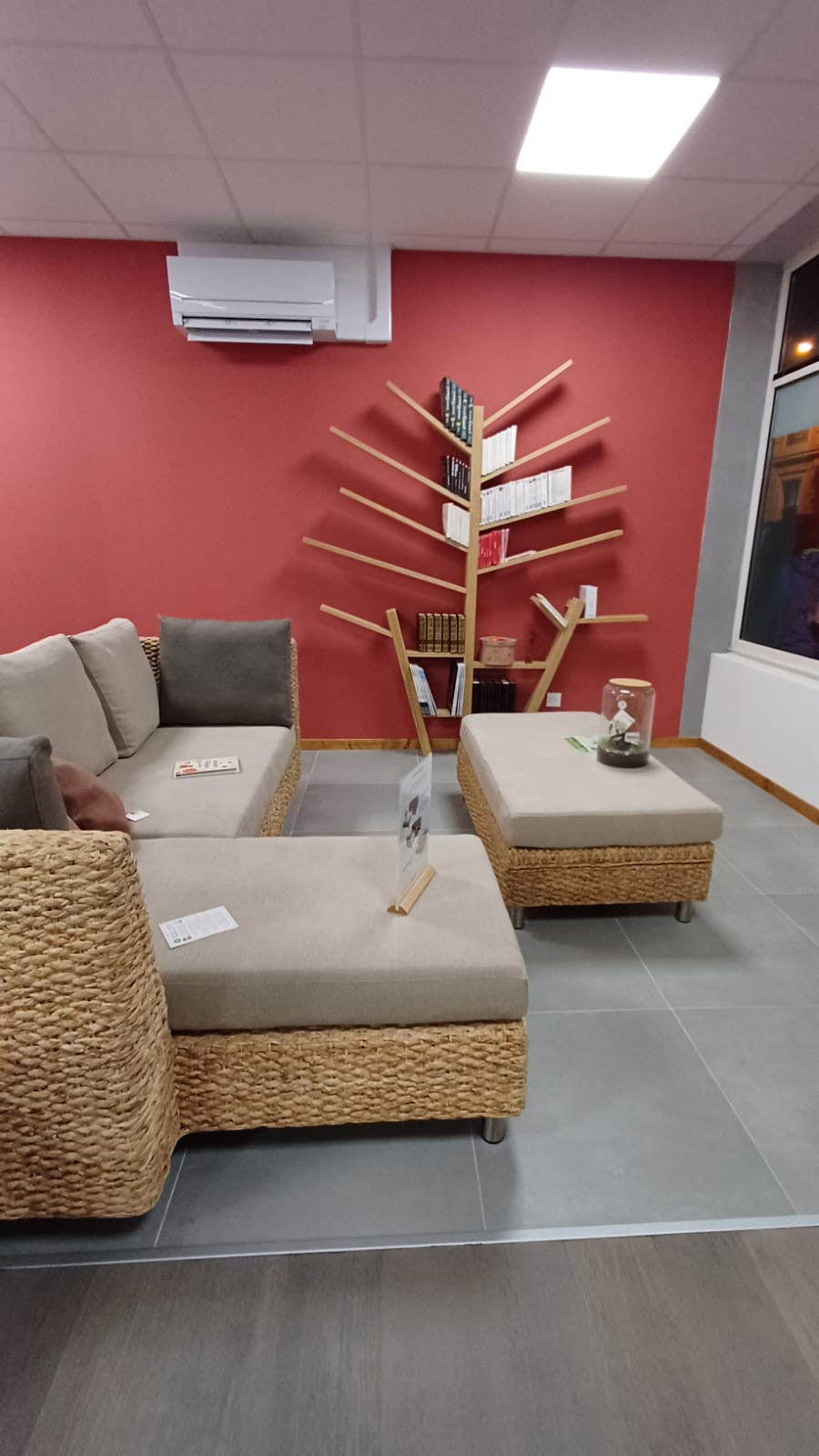 Mur peint avec le rouge 502 dans le showroom à Grenoble. Beau contraste avec le bois et la jacinthe d'eau tressé du canapé et de