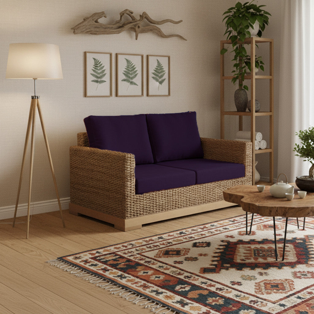 Petit canapé biologique et naturel à l’emplacement salon, avec coussins violets, table basse en bois et étagère végétale.