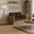 Petit canapé bio et naturel en jacinthe d'eau tressée, coussins marron dans un salon cozy avec tapis, lampadaire et plantes.