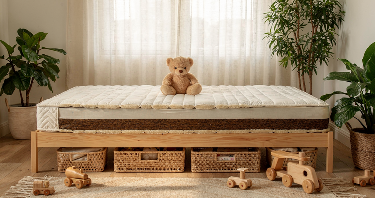 Matelas bio pour enfants et ados: grand lit en bois avec matelas moelleux et ours en peluche, entouré de plantes d’intérieur et